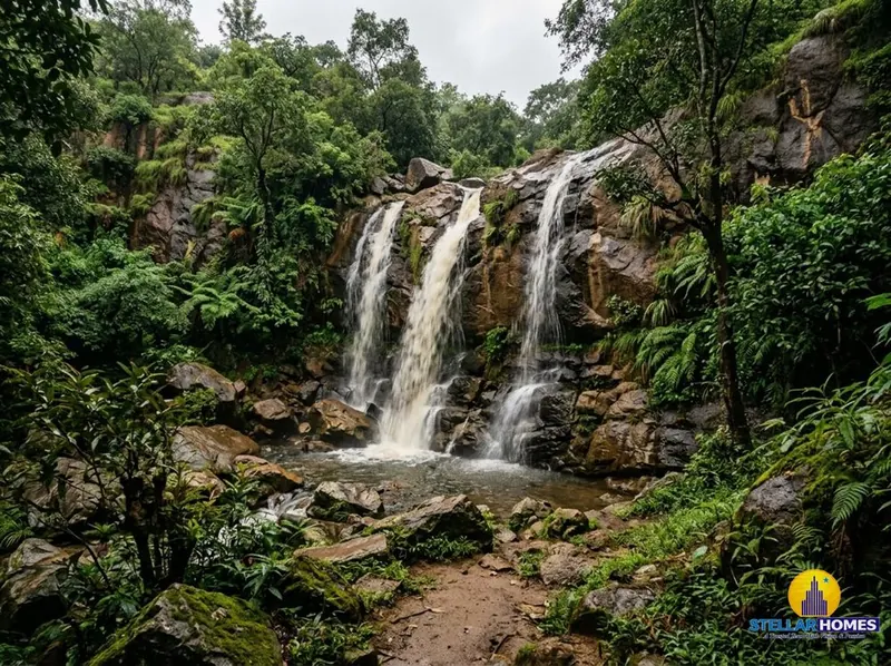 Kethanahalli Falls cascading over layered granite rocks into a green pool surrounded by dense forest